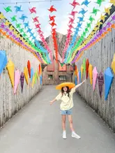 A bright, well-composed photo of a child wearing a sombrero in a pathway decorated with colourful pinwheels at Hertfordshire Zoo, capturing a fun, family-friendly atmosphere.