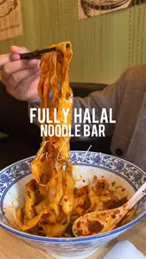 A short, punchy review of a noodle bar in London, featuring close-up shots of hand-pulled noodles, lamb skewers, and a beef rougamo. The video captures the ordering process, kitchen preparation, and the final dishes, providing a clear look at the food quality and menu variety.