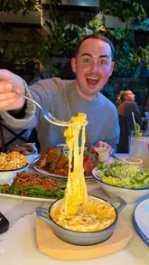 A fast-paced, engaging review of Butter Bird in Manchester, focusing on their rotisserie chicken concept. The video features close-ups of the chicken being basted with various flavoured butters, alongside sides like mac and cheese, potatoes, and salad. The creator provides enthusiastic commentary on the flavours and textures, effectively selling the dining experience.