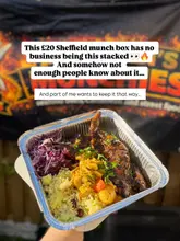 A casual, handheld shot of a Caribbean takeaway meal in a foil container, held in front of a branded banner. The image is clearly intended for social media promotion, focusing on the portion size and the 'munch box' concept.