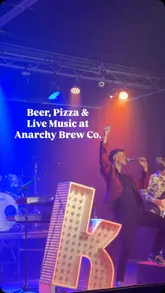 A montage video showcasing Anarchy Brew Co, featuring craft beer being poured, pizza from Rebel Crust, and a live music performance by The Killaz UK.