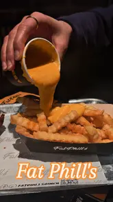 A short, fast-paced video showcasing burgers, fries, and cheese sauce at Fat Phill's in Dublin, featuring close-up shots of the food being prepared and eaten.