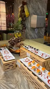 A montage-style venue tour of a Korean-style buffet restaurant, showcasing the sushi station, raw hotpot ingredients, dipping sauce bar, and dessert section.