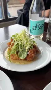 A food vlog featuring a visit to Miga, a Korean restaurant. The creator showcases various dishes including fried chicken, sashimi, mung bean pancake, pork belly, and soy-braised short rib, providing positive commentary on the food quality and taste.