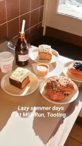 A short, handheld-style reel showcasing a visit to Milk Run in Tooting. The video features close-ups of various pastries, coffee, the cafe's interior, and a dog sitting outside, creating a relaxed and inviting atmosphere.