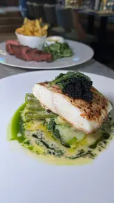 A creator visits two connected venues in St Andrews, The Adamson and The Physician, showcasing a variety of high-end dishes including oysters, scallops, mussels, halibut, and steak frites, alongside a selection of cocktails and mocktails.