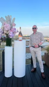 A montage video capturing a 20th-anniversary event for Whispering Angel rosé on a rooftop venue. The video features shots of the wine being poured, guests enjoying the drinks, the venue's rooftop setting, and a DJ, highlighting the celebratory atmosphere.