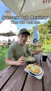 A creator visits a local pub, The Old Oak Inn, to review the atmosphere and food, specifically trying the chicken caesar salad and parmesan truffle chips.