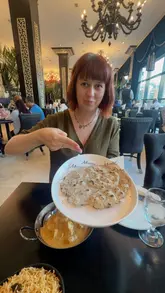 A review-style video featuring two creators discussing their dining experience at Mumtaz Leeds, specifically highlighting the availability of gluten-free rotis and various Indian dishes.