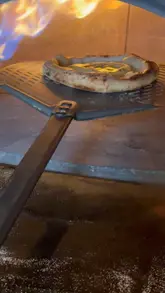 A behind-the-scenes video showing the pizza-making process at Pizzarova, featuring the creator preparing dough and topping pizzas.