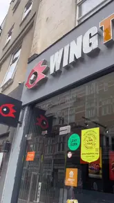 A food review video showcasing the new Nashville-inspired menu at WingTrapp, featuring various chicken dishes, loaded sides, and a notable cheese pull.