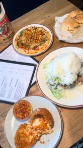 A review of the new menu at Ornella's Kitchen in Manchester, featuring a variety of dishes including hummus, focaccia, arancini, crispy chicken caesar salad, crab linguine, and beef short rib with gnocchi.