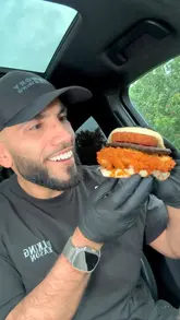 A food review of Szzle Bite in Blackburn, featuring a variety of fried chicken burgers and wings. The creator visits the venue, shows the preparation process, and gives a taste test review from his car.