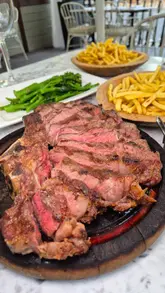 A montage showcasing the exterior, interior, and outdoor terrace of Cent Anni restaurant, featuring close-up shots of steak, burrata, shrimp, cocktails, and tiramisu.