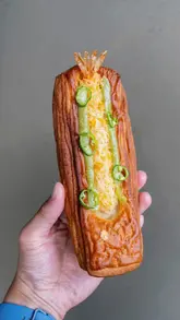 A showcase of various pastries and drinks from a London bakery, highlighting unique fusion flavours like black sesame, lemongrass, and yuzu wasabi.