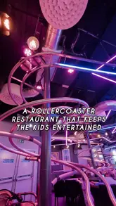 A short, energetic video showcasing a restaurant where food is delivered to tables via a rollercoaster track system. The video captures the movement of the tracks and the excitement of the dining experience, suitable for families.