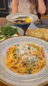 A short promotional video showcasing a meal and drinks at a Bella Italia restaurant, highlighting a special offer on spritzes. The video features close-up shots of pasta, salad, garlic bread, and cocktails, with the creator appearing to enjoy the experience.
