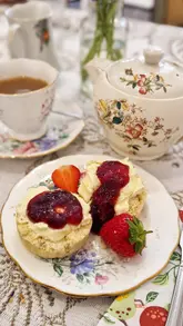A montage showcasing a gluten-free afternoon tea experience at Ashwell & Co, a vintage clothing store. The video features close-ups of the three-tier stand, including sandwiches, cakes, and scones, alongside shots of the venue's interior.