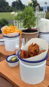 A short, montage-style video showcasing 'The Chicken Coop' pop-up at the Gleneagles hotel. The video features shots of the outdoor lawn seating, the menu, and the casual fried chicken and fries served in branded packaging.