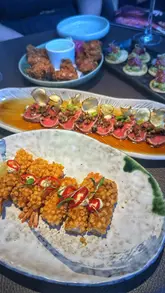 A first-person review of a bottomless brunch experience at Sticks'n'Sushi in Manchester. The video features close-up shots of various Japanese dishes, including sushi, nigiri, and tempura, alongside clips of drinks being poured and the restaurant's interior.