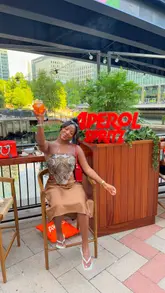 A vibrant vlog-style reel showcasing the new terrace at Six by Nico in Canary Wharf. The video features the creator enjoying £5 Aperol Spritz cocktails and small plates by the water, highlighting the lively atmosphere with a DJ and the scenic outdoor setting.