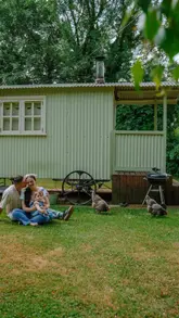 A family vlog showcasing a stay at a shepherd's hut lodge, highlighting the peaceful nature setting, breakfast cooking, and interactions with resident chickens.