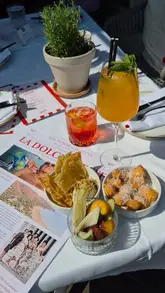 A short, static video showcasing an aperitivo spread at Eusebi's Deli, featuring cocktails like Spritz and Negroni alongside small plates on an outdoor table.