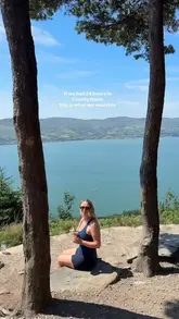 A travel-focused social media post featuring a scenic, outdoor lifestyle shot of a person enjoying a coffee with a view of a lough in County Down. The image serves as an introduction to a listicle itinerary for a 24-hour trip.