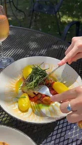 A montage of food and drink shots at The George at Woolley, featuring close-ups of various dishes like pork belly, stone bass, and desserts, alongside shots of the pub's outdoor garden area.