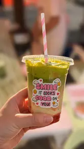 The video features a creator visiting a market stall called The Matcha Mam at a food festival. It includes a personal introduction in a car, followed by footage of the stall, the preparation of a strawberry matcha drink, and the final product.