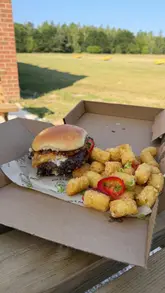 A review of Par & Patty, a burger venue located at Yarm Driving Range. The video features close-ups of smash burgers, tater tots, fries, and mozzarella sticks, followed by a tour of the driving range facilities and the 'Smash and Swing' deal.