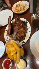 A personal vlog-style review of a visit to Blacklock, featuring shots of the menu, the restaurant interior, a large meat sharing platter, sides, and a tableside dessert service.