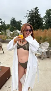 A lifestyle reel featuring a woman enjoying a spa day at a hotel, showcasing the outdoor pool, loungers, and a barrel hot tub while enjoying a cocktail.