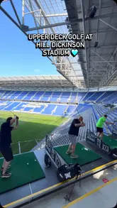 A promotional video showcasing the 'Upper Deck Golf' experience at Everton's stadium, featuring people hitting golf balls from the stands, various golf challenges, and food and drink options.