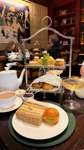 A visually appealing montage showcasing an afternoon tea service at The Beaumont Mayfair, featuring shots of the elegant Gatsby Room, the tea stand, pastries, and live piano music.