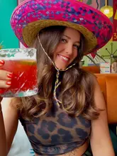 A vibrant, high-quality portrait of a creator holding a margarita at Motel Mexicana, effectively showcasing the venue's colorful and fun atmosphere through a well-composed, engaging shot.