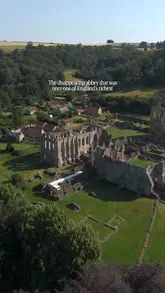 A cinematic montage of Rievaulx Abbey in North Yorkshire, featuring sweeping drone shots and close-ups of the ruins, accompanied by text overlays explaining its history.