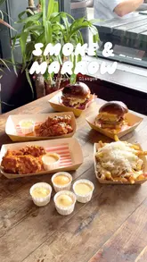 A short, energetic video showcasing a burger pop-up called Smoke & Marrow, featuring close-ups of burgers, fried chicken, fries, and cocktails, along with the creator enjoying the food in a pub setting.