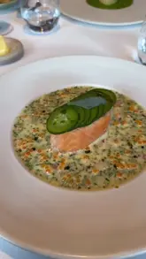 A montage of high-end dishes and wine service at a restaurant, featuring close-up shots of plated food and table service.