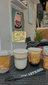 A creator visits a Cupp bubble tea shop to review their new collaboration with Jimmy's Iced Coffee, showcasing the ordering process and tasting three different iced coffee drinks.