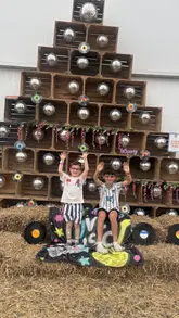 A montage of children enjoying various activities at FoxFest, including stage performances, fairground rides, and games at Conifox Adventure Park.