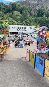 A short montage video showcasing the Neighbourgood Gardens pop-up venue in Edinburgh, featuring views of Edinburgh Castle, live music, and street food offerings like steak frites.