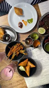 A montage-style video showcasing a meal at Dishoom, featuring various dishes like okra fries, curries, and lassis. The video highlights the restaurant's interior and menu items, providing a quick, engaging overview of the dining experience.