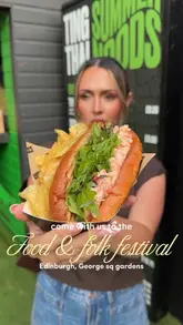 A person holds a lobster roll and chips at the Edinburgh Food & Folk Festival, promoting the event's street food offerings.