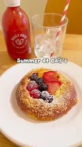 The creator visits a Gail's bakery to showcase their seasonal strawberry-themed menu, specifically featuring the berry brioche and a cold-pressed strawberry juice. The video includes close-ups of the food, a shot of the bakery counter, and the exterior of the shop.