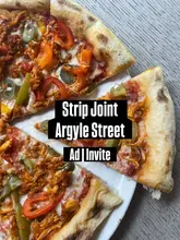 A top-down shot of a Cajun chicken pizza, heavily obscured by a large, central text overlay promoting the venue and the nature of the post.