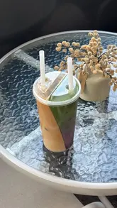 A creator visits a coffee shop in Kingston to try a unique 'split drink' that features both matcha and coffee in a single cup, showcasing the menu and the final product.