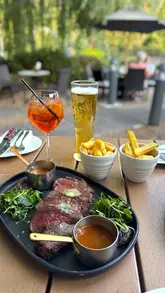 A montage of shots featuring the exterior and garden of The Belvedere Arms, followed by close-ups of cocktails, beer, and various dishes including steak, fries, and a fish risotto.