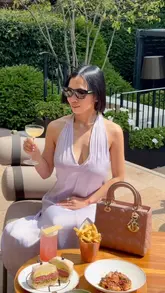A high-quality, aesthetic video showcasing the terrace at Bar Antoine, located at the Four Seasons Hotel London. The video features a woman enjoying cocktails and small plates in a sunny, upscale outdoor setting, highlighting the sophisticated atmosphere and the pétanque game available on the terrace.