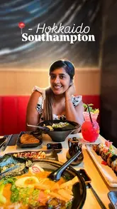 A portrait of a diner at a Japanese restaurant in Southampton, featuring a spread of sushi, ramen, and a cocktail.